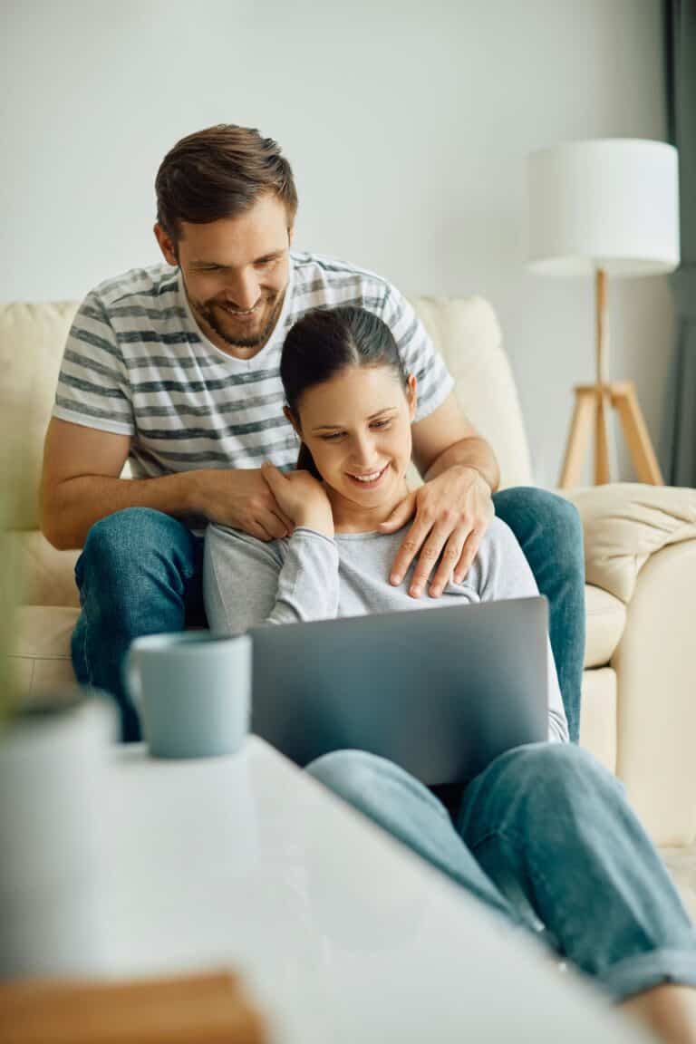 eine Frau und ein Mann schauen auf einen Laptop
