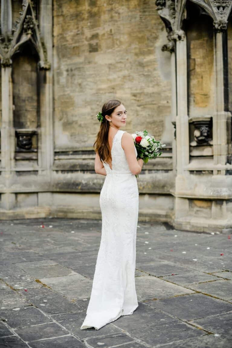 Braut in einem engen Brautkleid vor der Kirche