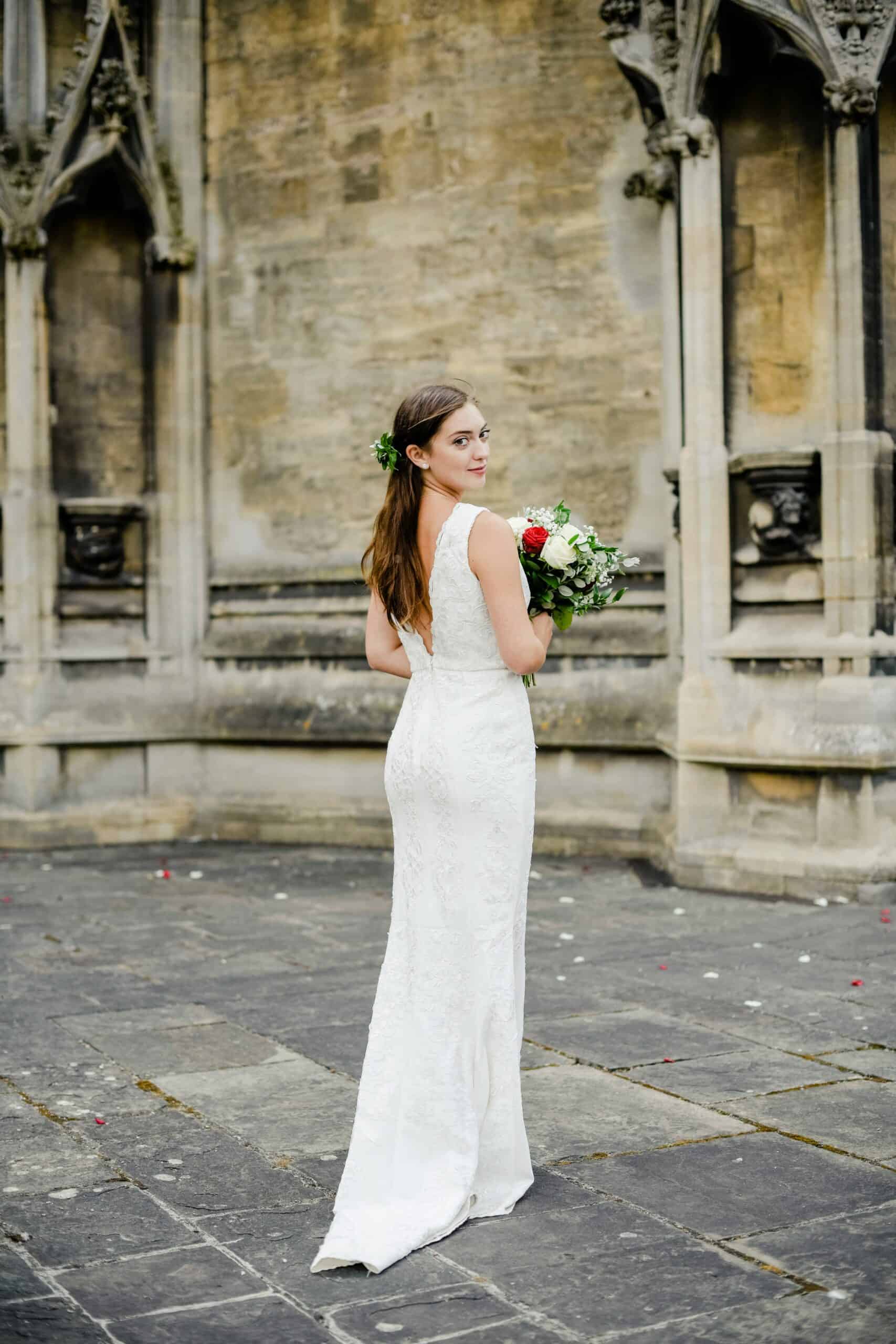 Braut in einem engen Brautkleid vor der Kirche